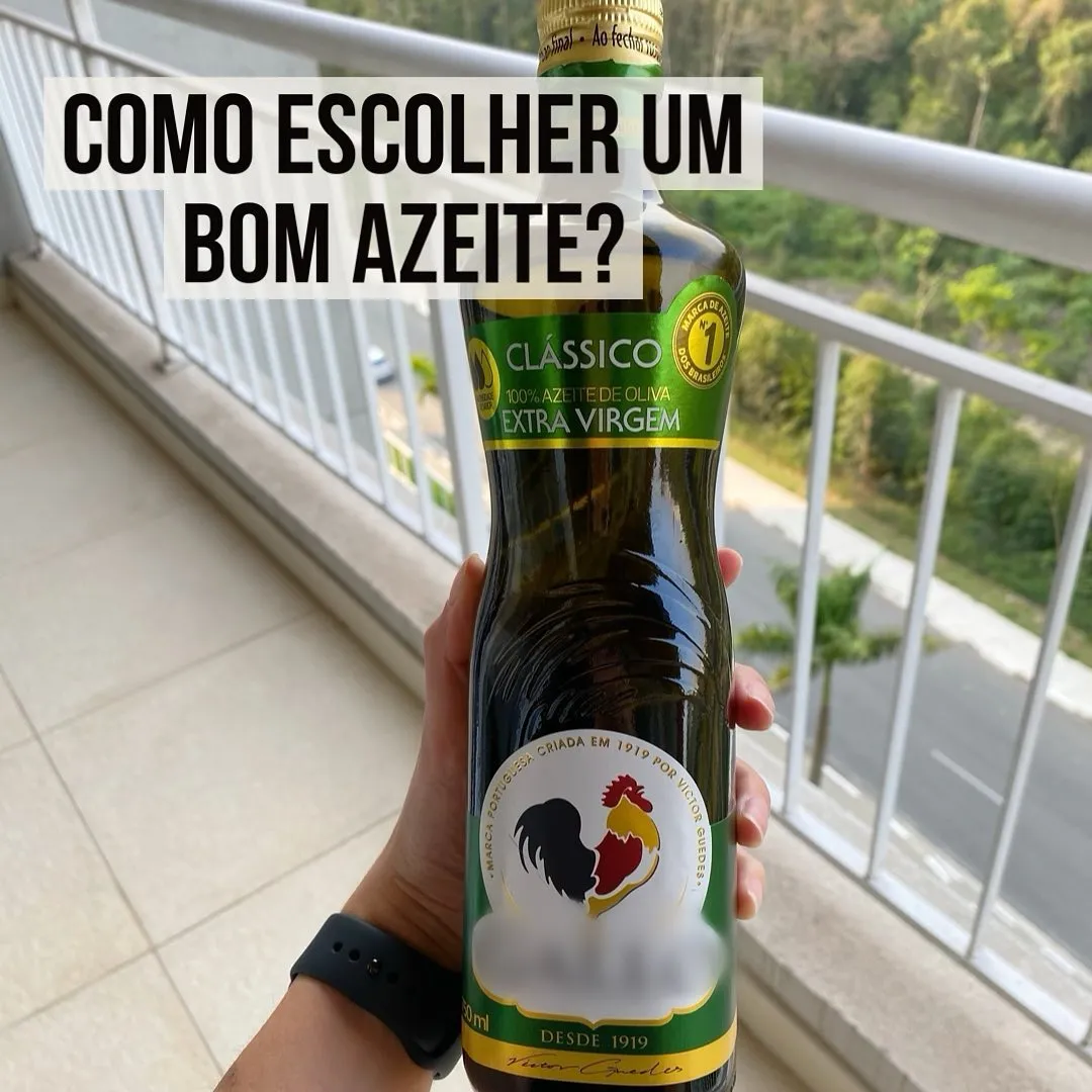 Mão segurando garrafa de vidro escuro de azeite de oliva extra virgem numa varanda