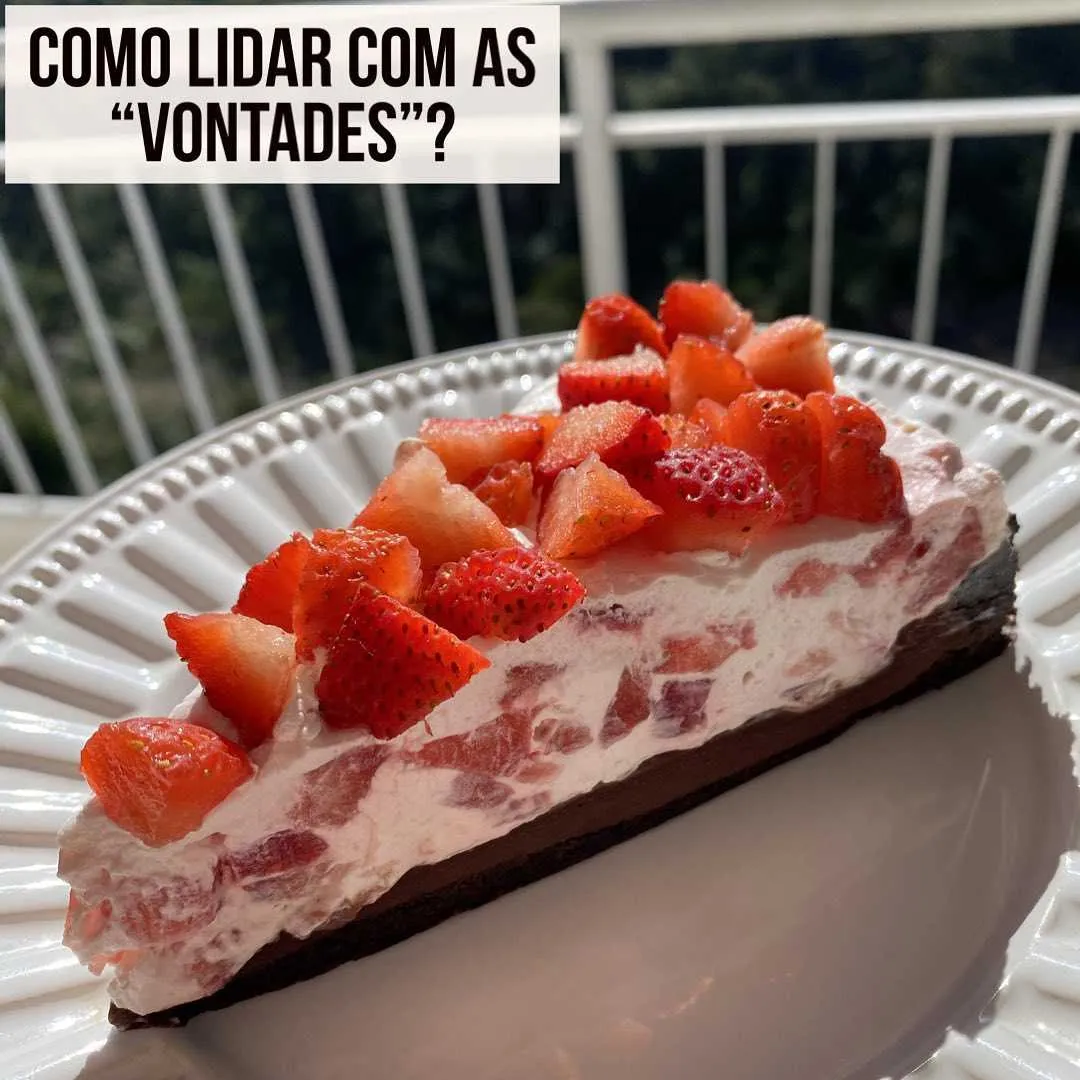 Fatia de torta de morango com base de chocolate no prato e título sobre como lidar com as vontades