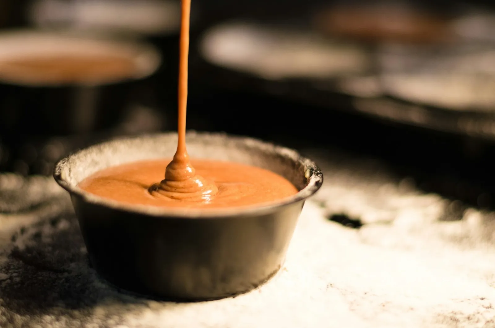 Doce de leite cremoso sendo despejado em forma de metal, fonte de carboidrato rápido no pré-treino