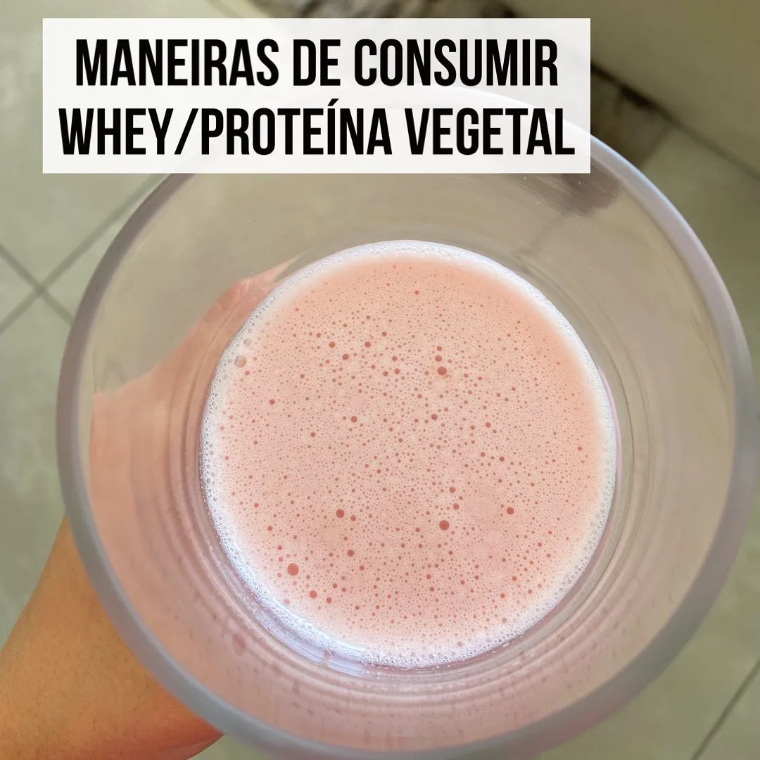Copo com shake rosado de whey ou proteína vegetal batido, visto de cima