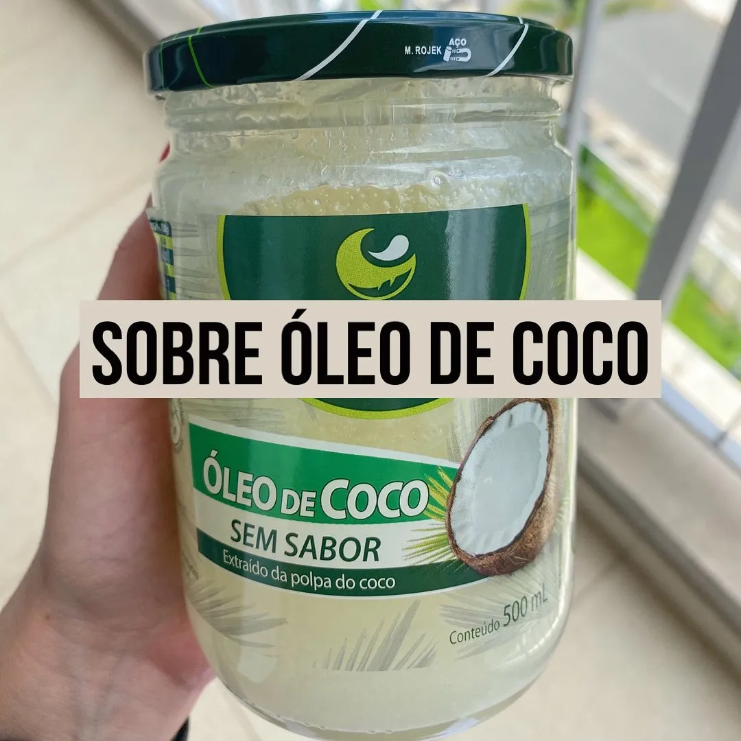 Pote de oleo de coco sem sabor segurado na mao perto de uma janela